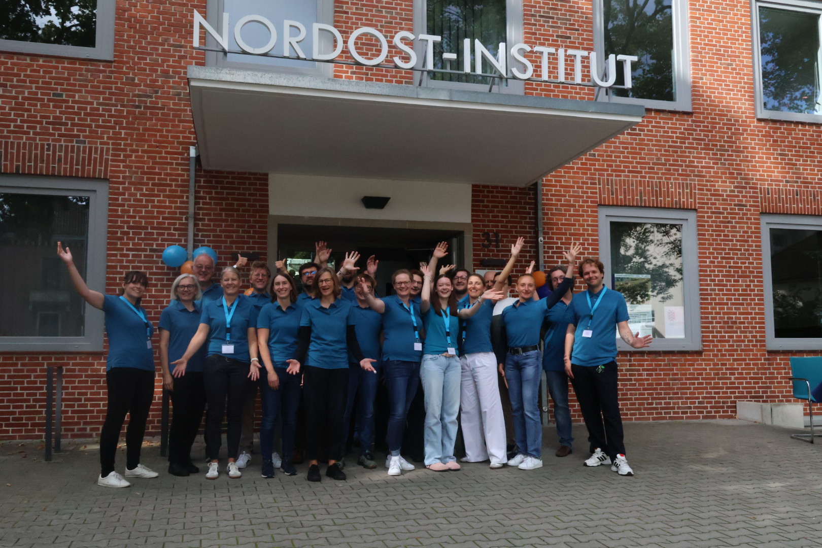 Das Bild zeigt das etwa zwanzigköpfige Team des Nordost-Instituts vor dem Gebäude des Instituts